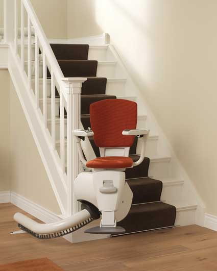 Sitzlift für kurvige Treppen mit maßgefertigter Schiene – Beispiel mit rotem Sitz